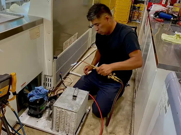 Cirilo brazing a line on commercial refrigeration equipment in a restaurant
