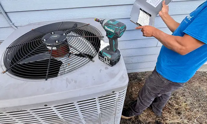 Pacific Breeze HVAC technician testing a residential air conditioning condenser