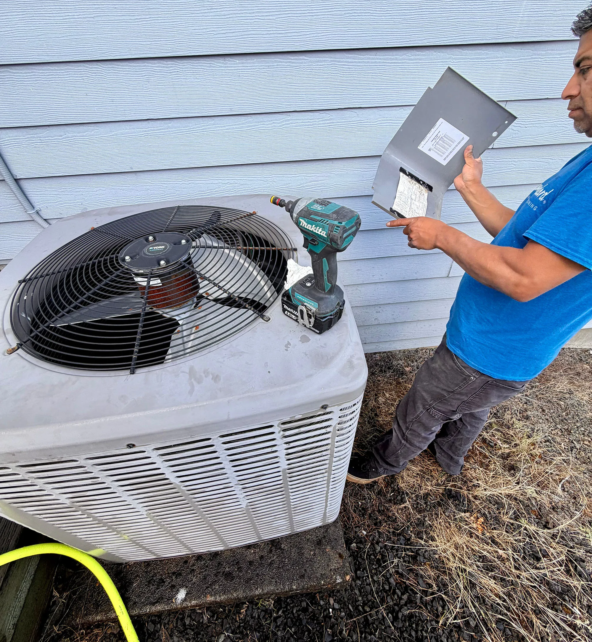 Pacific Breeze HVAC technician testing a residential air conditioning condenser