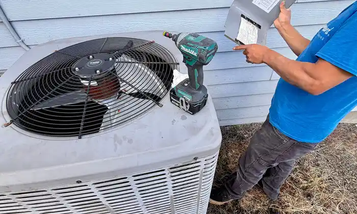 Pacific Breeze HVAC technician testing a residential air conditioning condenser